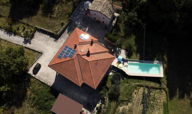 Casa in pietra con balcone e pareti rosa.